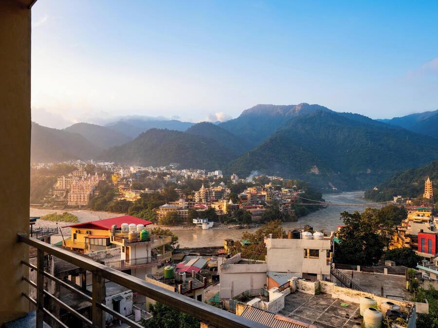 Une vue urbaine avec une rivière, des montagnes et un pont.