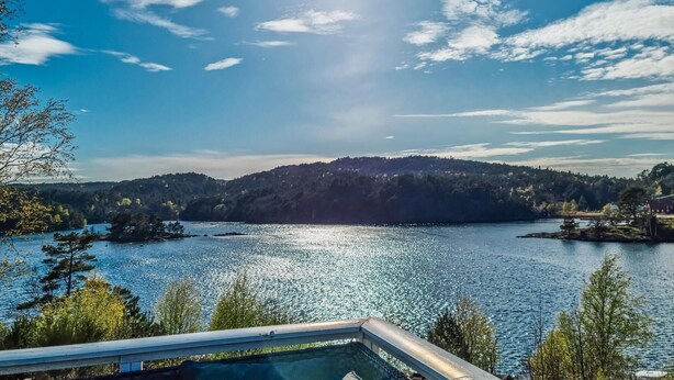A lake with a forested hill in the background and a swimming pool in the foreground. - 3 bedroom cozy apartment in Mandal (Mandal)
