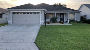 A residential house with a garage, a well-maintained lawn, and a clear sky. - New Renovated House in Spanish Springs The Villages  (The Villages)