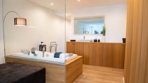 Une salle de bain moderne avec un meuble-lavabo en bois, un grand miroir et un banc noir.