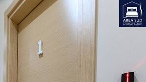 A wooden door with a numeric keypad lock and a small sign indicating room number 1. - South Area Guesthouse (self check-in) (Canicattì)