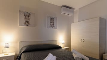 Une chambre d’hôtel avec un lit, une armoire, une table de chevet et des œuvres d’art murales.