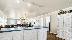 A spacious kitchen with a large island, white cabinetry, and a wooden floor. - 4 Bedroom 2 Bath Ocean Front Vacation Rental on Edisto Beach (Edisto Beach)
