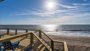 A wooden deck with a metal railing overlooking a beach. - 4 Bedroom 2 Bath Ocean Front Vacation Rental on Edisto Beach (Edisto Beach)