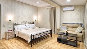 Une chambre à coucher comprenant un lit, une table de chevet, une commode et un canapé avec une table basse.