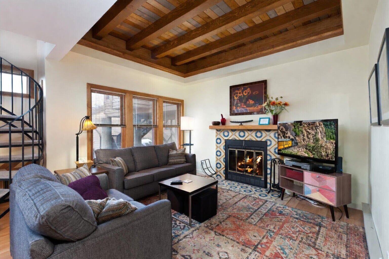 A living room with a fireplace, a sofa, a coffee table, and a TV.