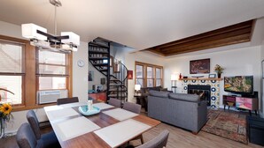 A modern living room with a dining area, a fireplace, and a staircase. - Durango Townhome w/ Pool/Hot Tub | Near FLC, Town, Golf & Trails (Durango)