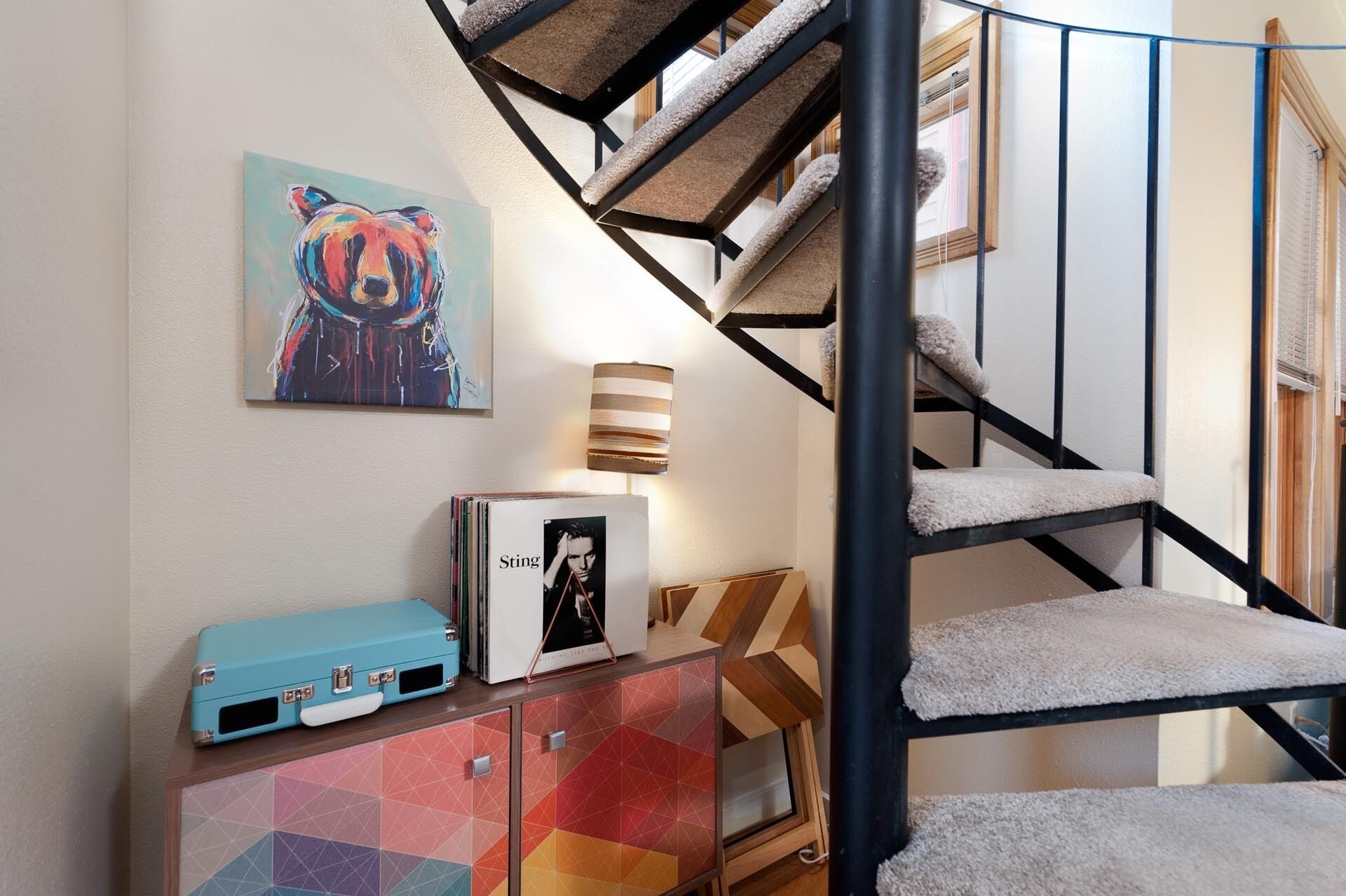 A staircase with a black metal railing and a beige carpet.