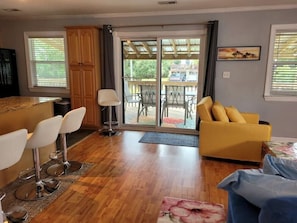 Een moderne keuken met een bar, een gele bank en een eettafel met stoelen.