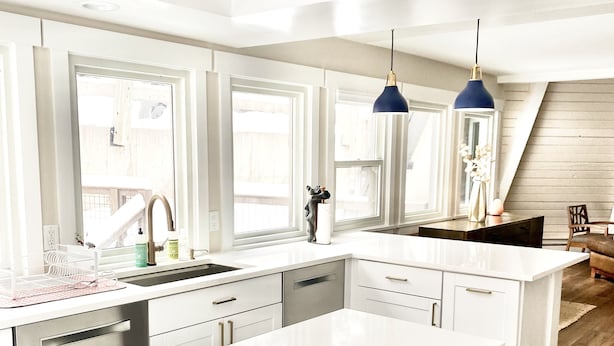 A modern kitchen with white cabinetry, a large island, and pendant lighting. - 6 bedroom modern West Vail Home w/2 large decks, 300 yds from Vail free shuttle (Vail)