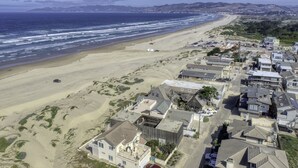 Zona residencial costera con casas, una playa y vistas al océano.