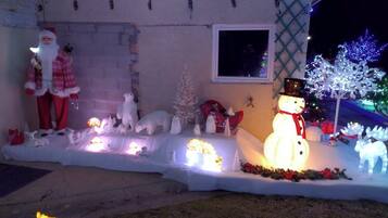 Une maison décorée de guirlandes lumineuses de Noël, avec notamment un bonhomme de neige, des rennes et le Père Noël.