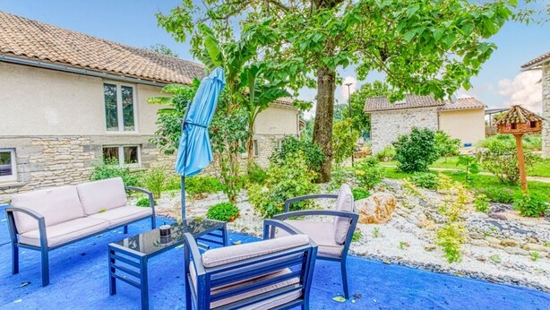 A patio with outdoor furniture, a covered table, and a tree providing shade. - Belle Quercynoise with private Hammam and jacuzzi (Septfonds)