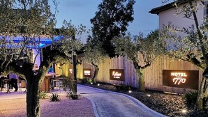 L’entrée d’un hôtel avec un chemin de gravier, une clôture en bois et des panneaux lumineux.