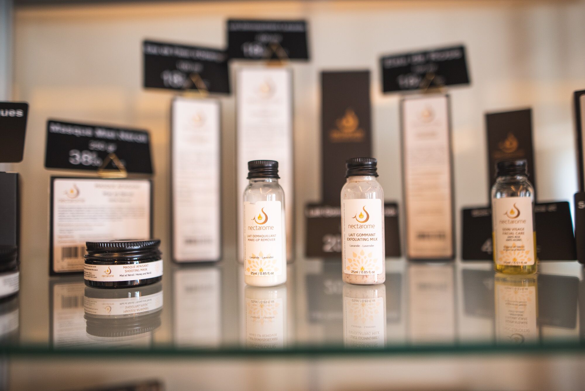 Une sélection de produits de soins pour la peau exposée sur une étagère en verre.