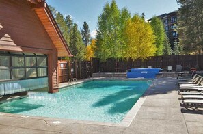 Relax by the pool surrounded by lush greenery and comfortable lounge chairs.