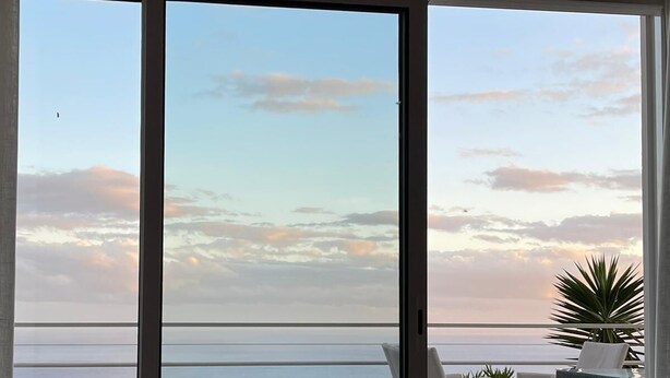 A balcony with a view of the sea and sky.