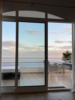 A balcony with a view of the sea and sky.