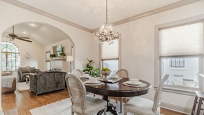 A dining area with a round table, chairs, and a chandelier. - Kessler Park Retreat - Walking distance to Bishop Arts District  (Dallas)