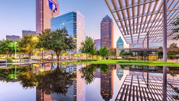 A modern urban plaza with reflective water, tall buildings, and a unique architectural structure with a slatted roof. - Kessler Park Retreat - Walking distance to Bishop Arts District  (Dallas)