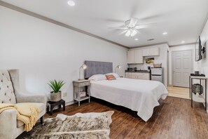 Une chambre à coucher avec un lit, une table de chevet, une lampe et une plante en pot.