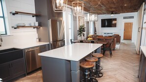 A modern kitchen with a central island, bar stools, and built-in appliances. - Modern Farm w/ 2 Kings: 20 min to Austin, COTA-Tesla (Elgin)