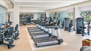 Une salle de sport moderne équipée de tapis de course, d’appareils de musculation et de matériel de cardio.