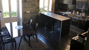 Et moderne køkken med en central ø, barstole, komfur og et indbygget ovn.