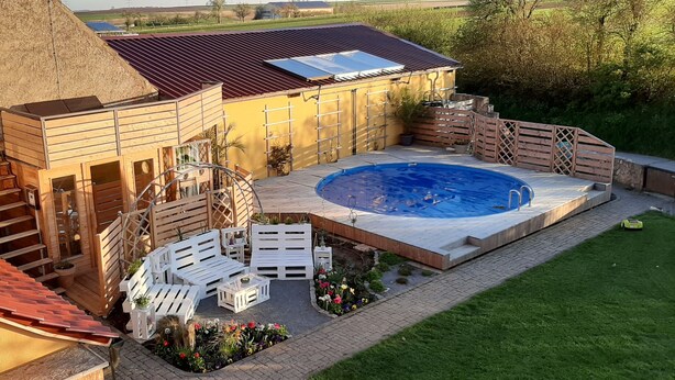 A backyard with a hot tub, wooden deck, and outdoor seating area. - Beautiful spacious apartment (Gaukönigshofen)