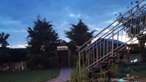 A garden pathway leading to a house with a wooden fence and a metal staircase. - Beautiful spacious apartment (Gaukönigshofen)