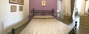 A bedroom with a bed, a dresser, a mirror, and a door leading to a bathroom. - Historic center of Naples - Anna's house, 5-minute walk to the beach (Napoli)
