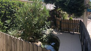 A wooden fence surrounding a garden area with a small pond and a wooden deck. - In Casteljaloux at the door of the Landes pretty villa of 190m² - French property (Casteljaloux)