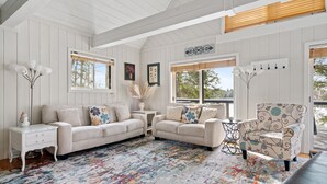 A cozy living room with a beige sofa set, a patterned armchair, and a colorful rug. - Peace on the Lake...close to Downtown Charlevoix (Charlevoix)