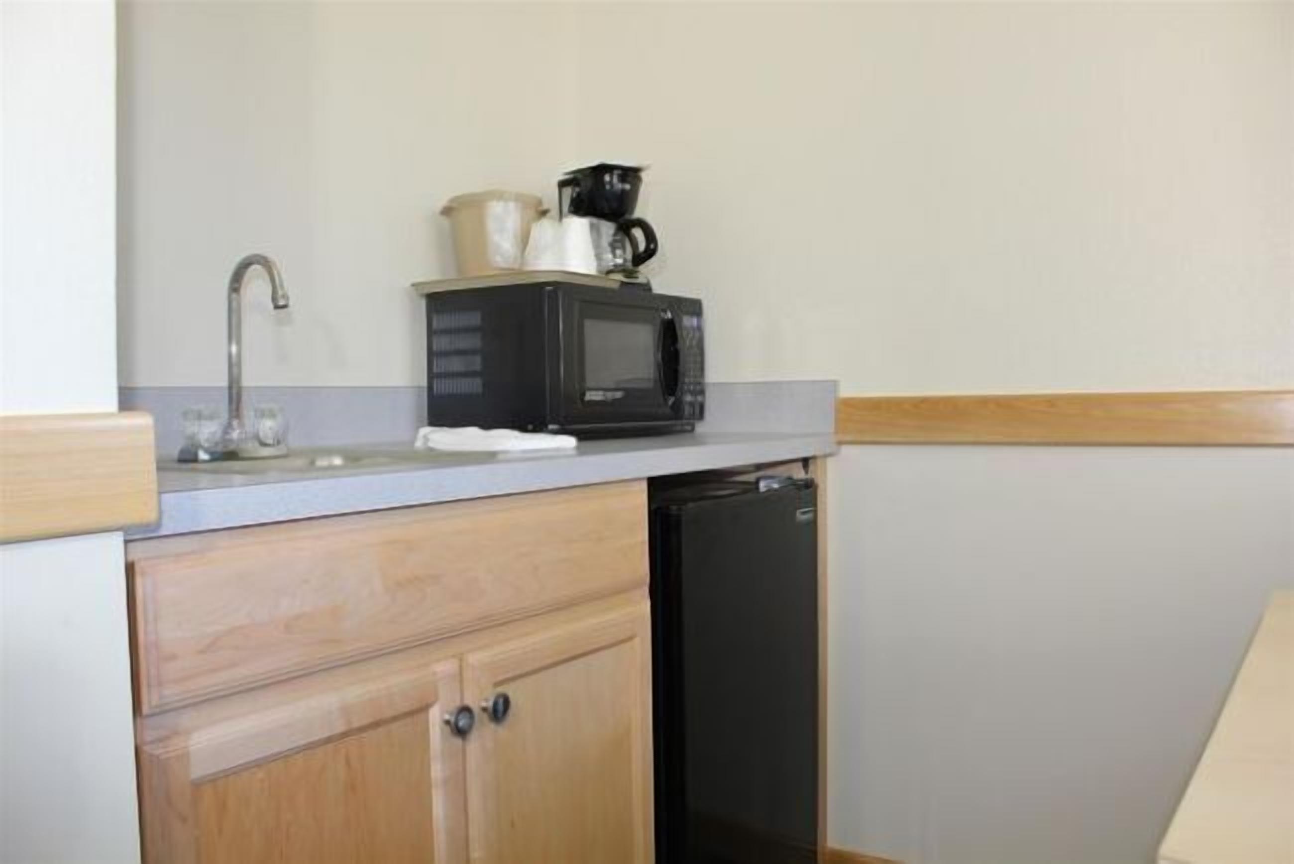 A compact kitchen with a microwave, coffee maker, and dishwasher.