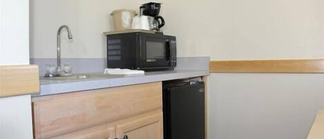 A compact kitchen with a microwave, coffee maker, and dishwasher.