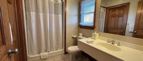 Un baño con bañera, inodoro, lavabo y espejo.