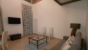 A living room with a sofa, a coffee table, a TV, and a lamp. - DUCHESS HOUSE (Varazze)