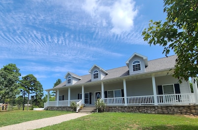 A large country home with scenic views of a working cattle farm & rural locale.