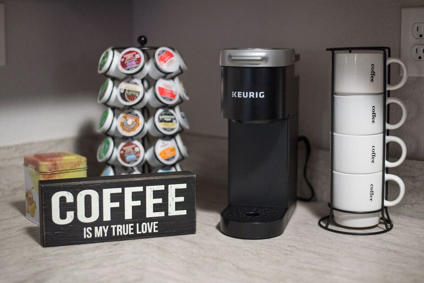 A coffee maker, a coffee mug holder, and a sign stating "COFFEE IS MY TRUE LOVE".