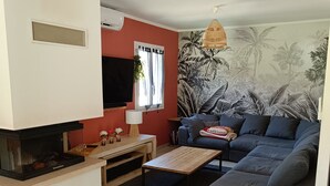 Un salon moderne avec un canapé, une table basse et un téléviseur.
