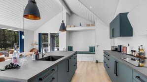 Una cocina moderna con una isla grande, electrodomésticos integrados y vistas al exterior.