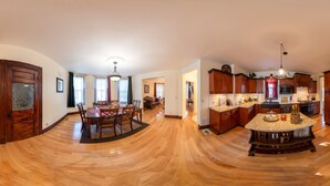 Una cocina amplia con armarios de madera, una isla central y un comedor con mesa y sillas.
