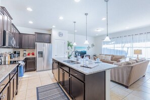 A modern kitchen with dark cabinets, stainless appliances, and a central island.