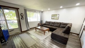 A living room with a sectional sofa, a glass coffee table, and a patterned rug. - Comfortable Gonzaga unit close to downtown Spokane (Spokane)