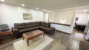 A living room with a sectional sofa, a wooden coffee table, and a rug. - Comfortable Gonzaga unit close to downtown Spokane (Spokane)