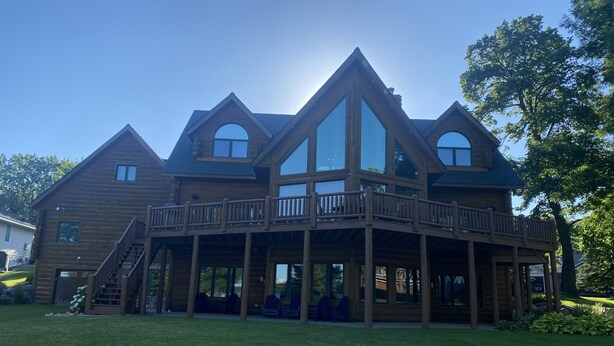 A large wooden house with a balcony and multiple windows.