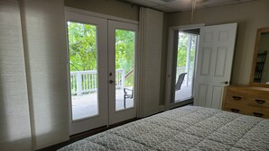Une chambre à coucher comprenant un lit, une commode et une porte donnant sur un balcon.