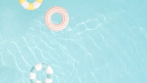 A clear blue pool with three floating rings.