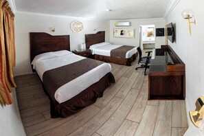 A hotel room with two beds, a desk, a chair, a TV, and an air conditioning unit. - Los Cedros Hotel Inn Chihuahua (Chihuahua)