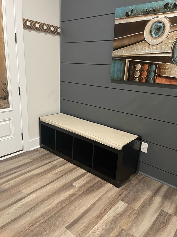 A room with a wooden floor, a bench, a door, and a wall with a textured design. - LUX Resort style spacious/Families&Professionals (Charlotte)
